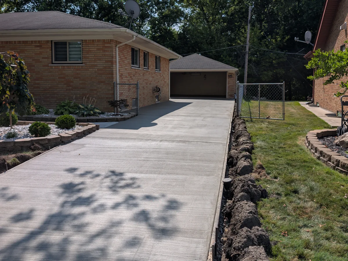 Freshly poured broom-finish concrete driveway running to a detached garage in Dearborn Heights, MI