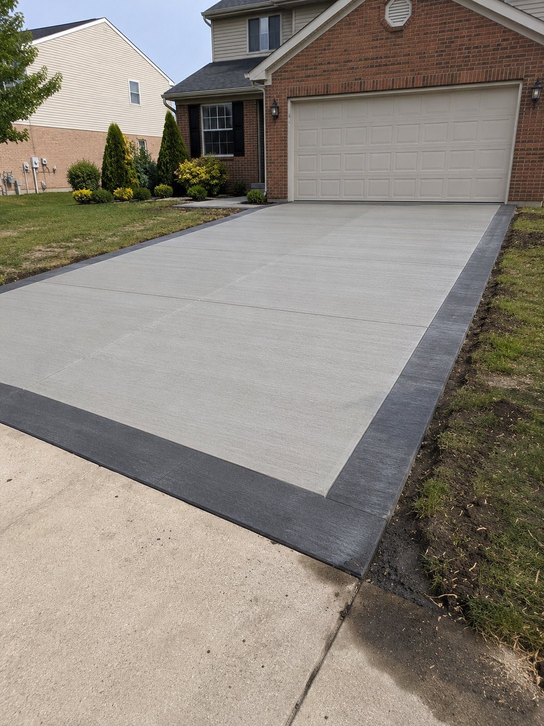 Concrete driveway with charcoal contrast border in Novi, MI