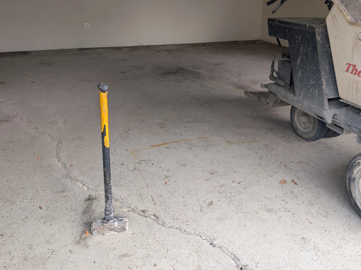 Cracked garage floor before replacement, with a wide crack running across the slab, Dearborn Heights MI