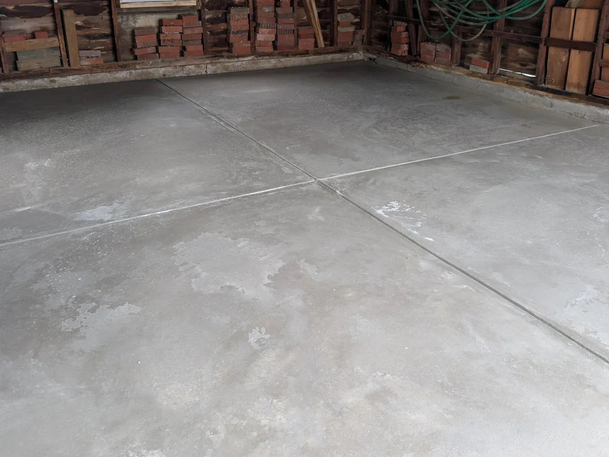 New broom-finish garage floor slab with saw-cut control joints in a detached garage, Dearborn MI
